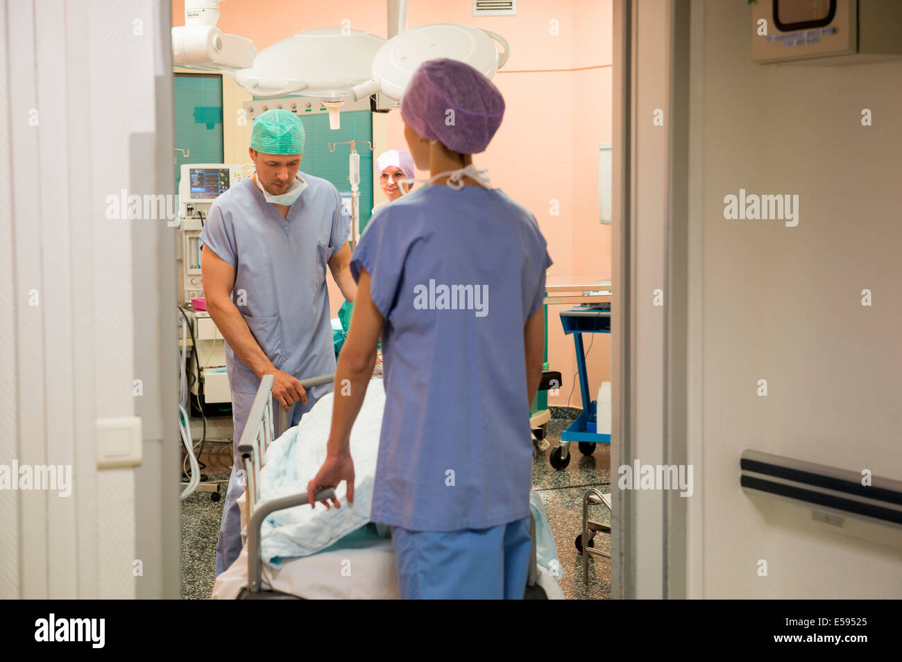 Médecin et l'infirmier de déplacer le patient en salle d'opération Banque D'Images