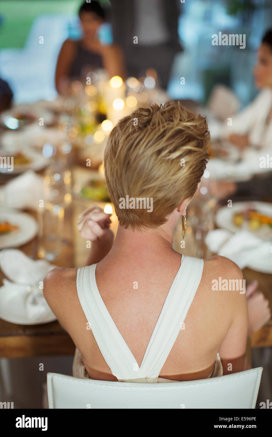 Woman sitting at dinner party Banque D'Images