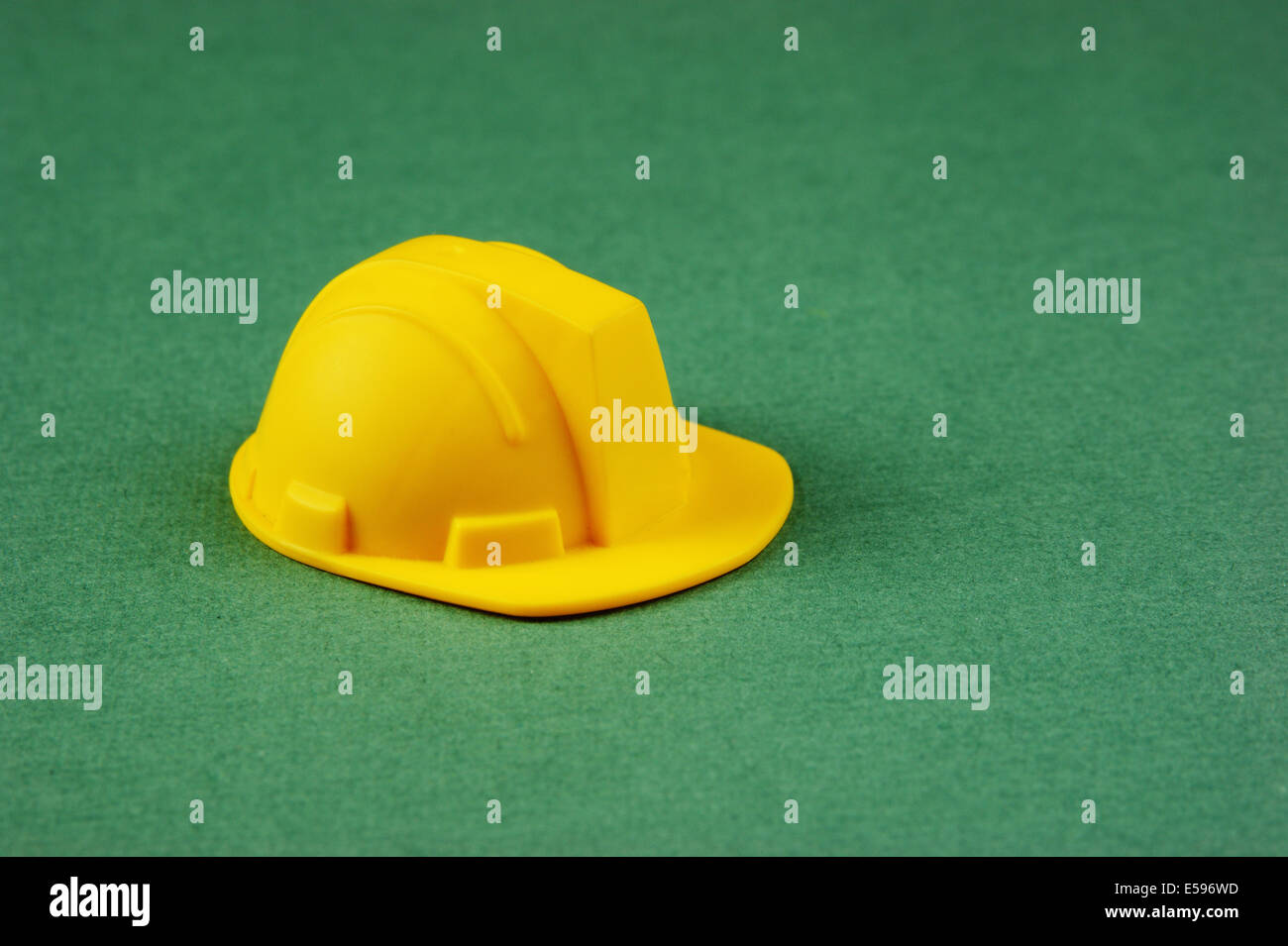 Casque de construction jaune en plastique sur le fond vert Banque D'Images