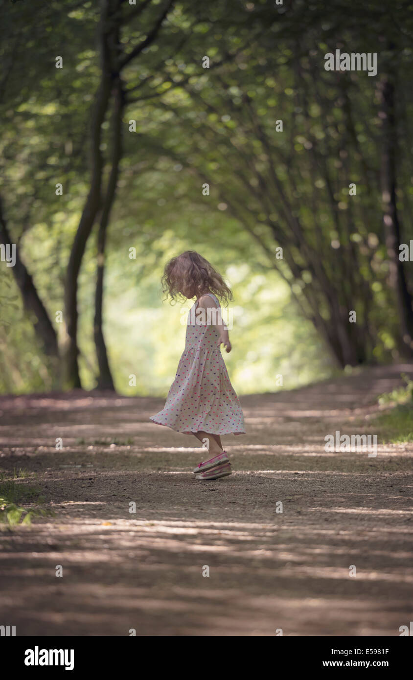 Petite fille dansant sur piste en forêt Banque D'Images