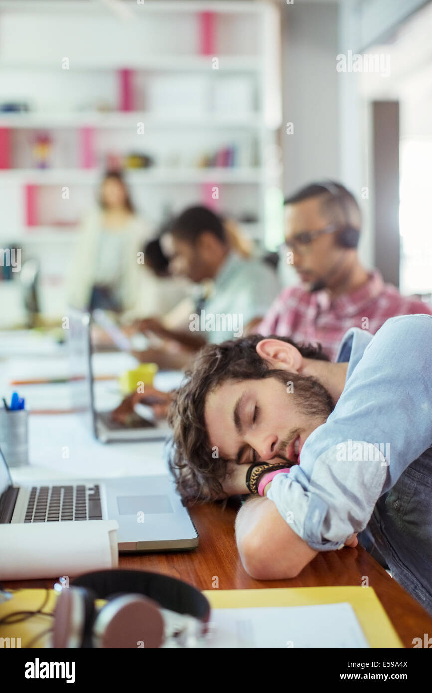 Man sleeping at desk in office Banque D'Images