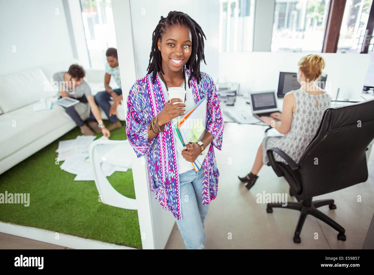 Woman drinking coffee in office Banque D'Images