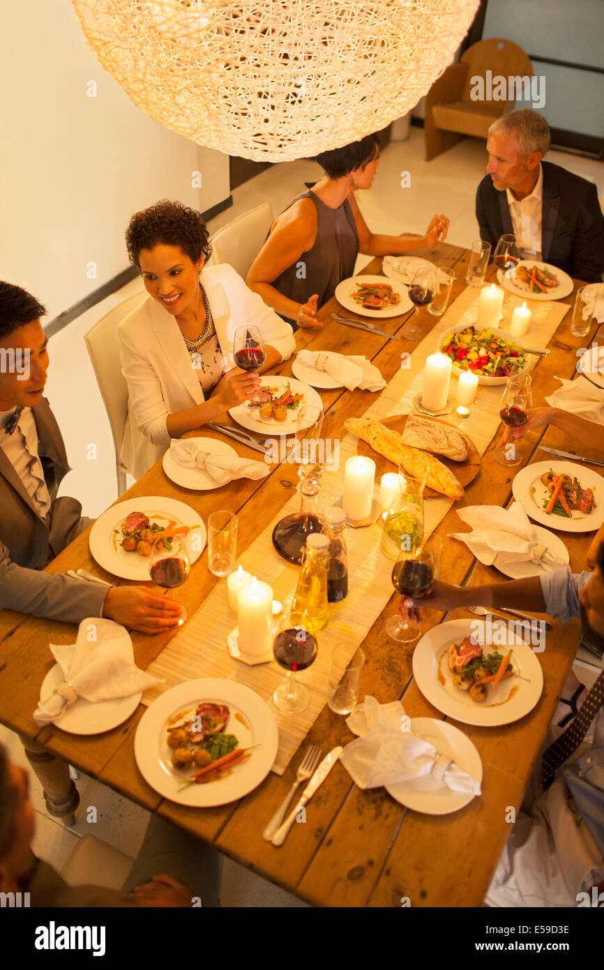 Les amis manger ensemble at dinner party Banque D'Images