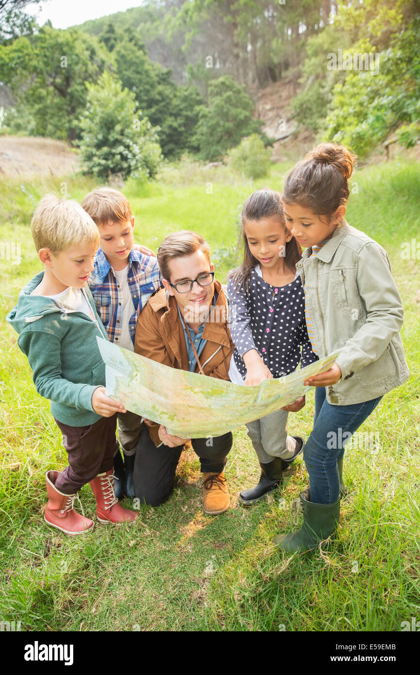 Les élèves et le professeur reading map in field Banque D'Images