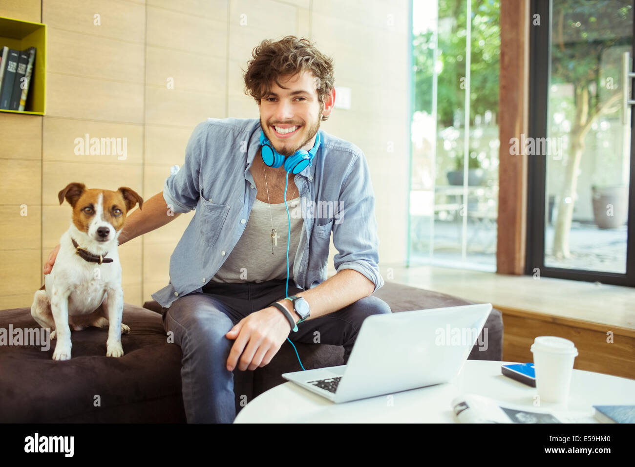 Man petting dog in office Banque D'Images