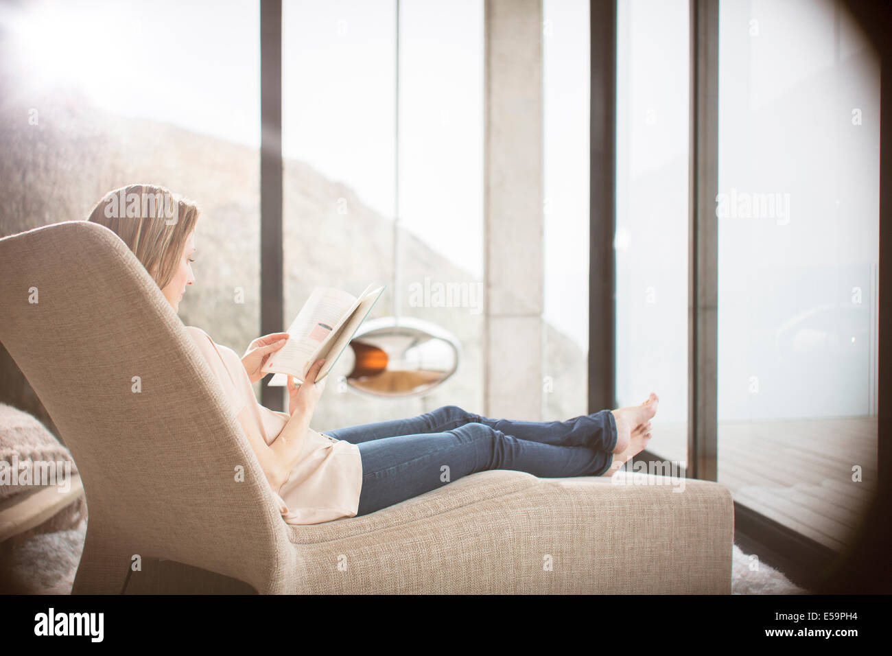 Woman on sofa in modern living room Banque D'Images