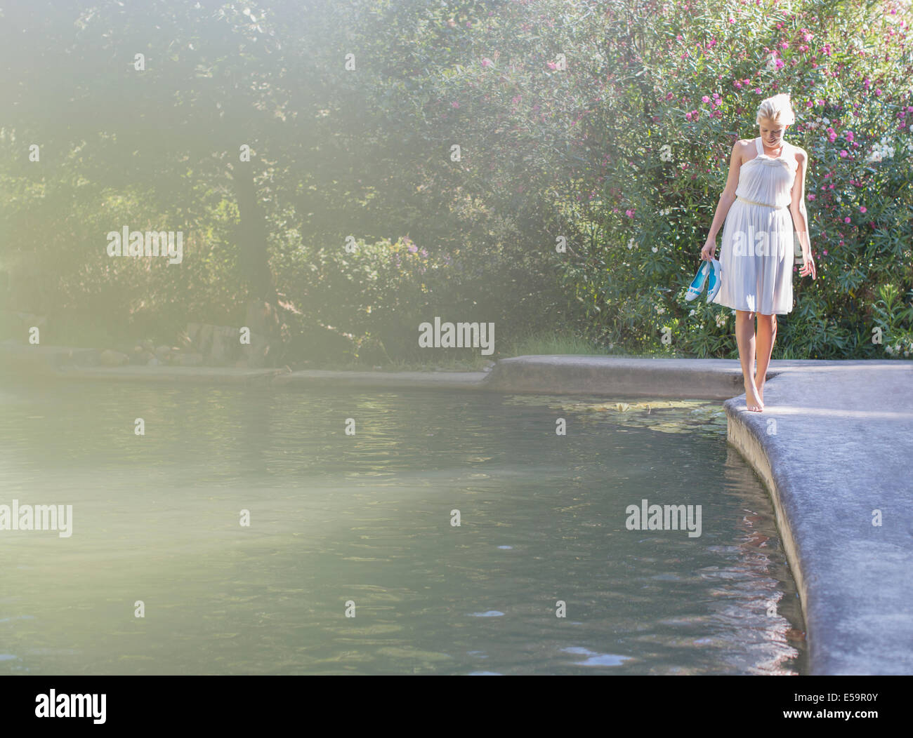 Femme marche en bord de piscine Banque D'Images