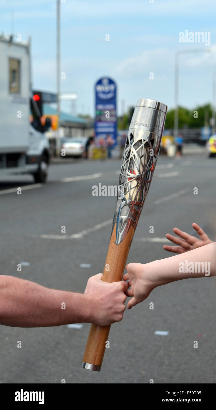 La Queens Baton Relay, le baton d'être touché par les enfants qui avaient attendu patiemment de voir le coureur Banque D'Images