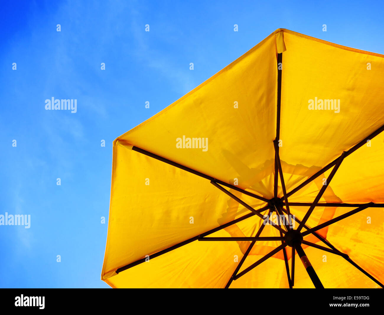 Parapluie jaune et bleu ciel symbolisant les vacances en été Banque D'Images