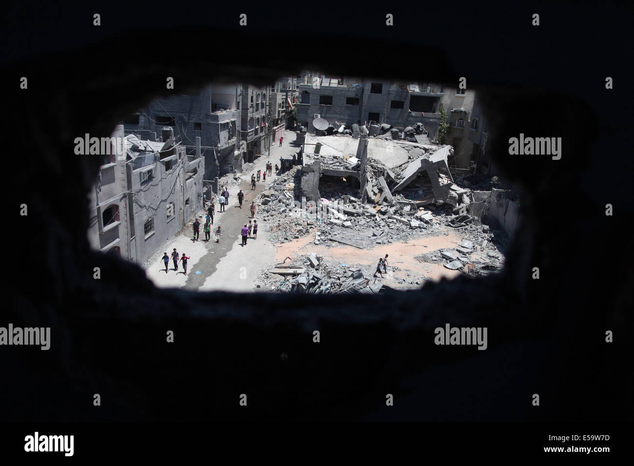 Gaza, bande de Gaza. 24 juillet, 2014. Inspecter un bâtiment palestinien détruit après une nuit passée dans les frappes israéliennes dans le camp de réfugiés de Jabalia, au nord de la bande de Gaza, le 24 juillet 2014. Le ministère de la santé à Gaza a dit dans une déclaration à la presse qu'au cours des 17 jours de l'offensive de grande envergure sur la bande de Gaza, l'armée israélienne a tué plus de 700 Palestiniens. Credit : Wissam Nassar/Xinhua/Alamy Live News Banque D'Images