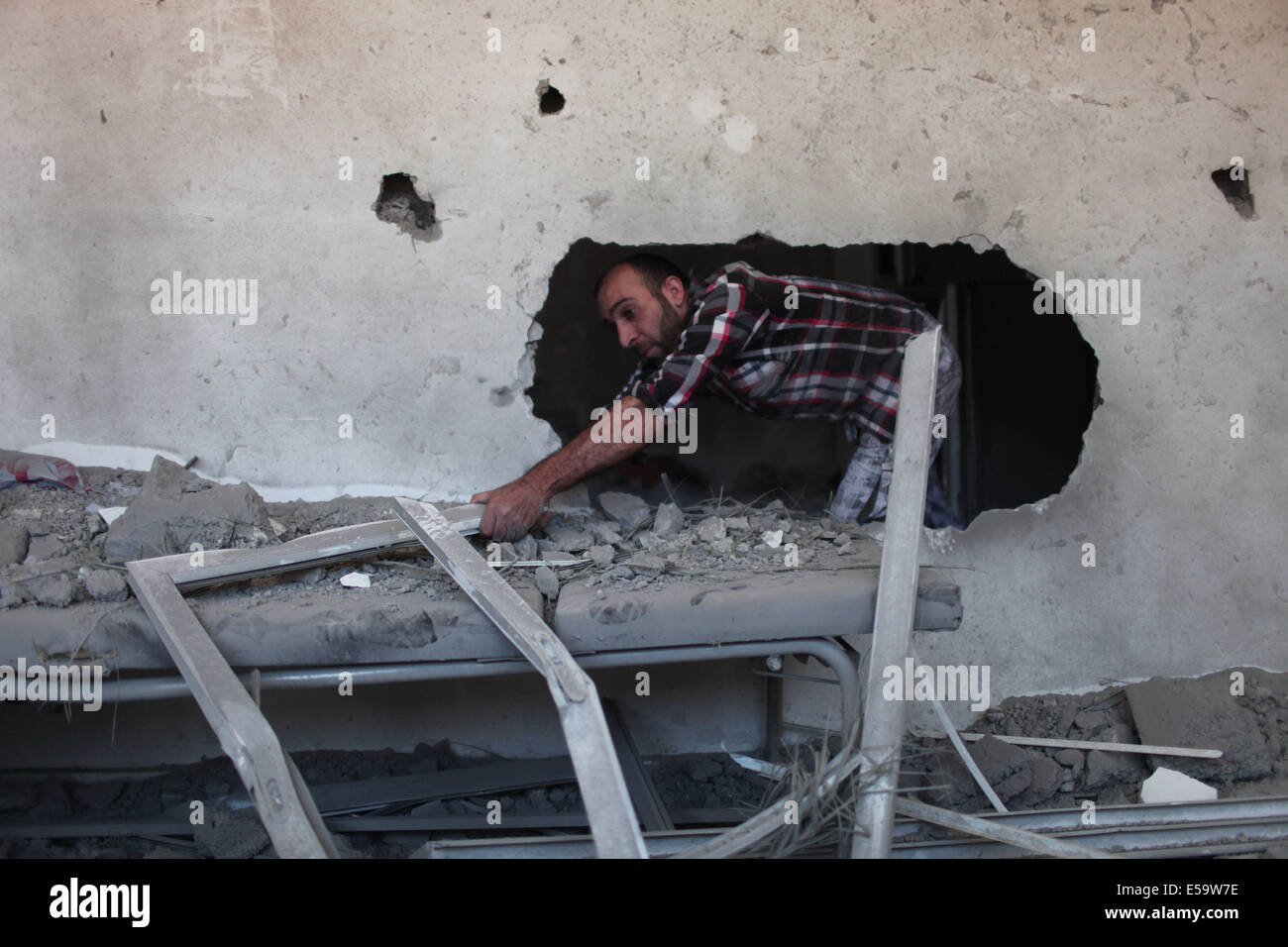 Gaza, bande de Gaza. 24 juillet, 2014. Un palestinien est perçu sur les débris d'un bâtiment détruit à la suite d'une attaque aérienne israélienne la nuit dans le camp de réfugiés de Jabalia, au nord de la bande de Gaza, le 24 juillet 2014. Le ministère de la santé à Gaza a dit dans une déclaration à la presse qu'au cours des 17 jours de l'offensive de grande envergure sur la bande de Gaza, l'armée israélienne a tué plus de 700 Palestiniens. Credit : Wissam Nassar/Xinhua/Alamy Live News Banque D'Images