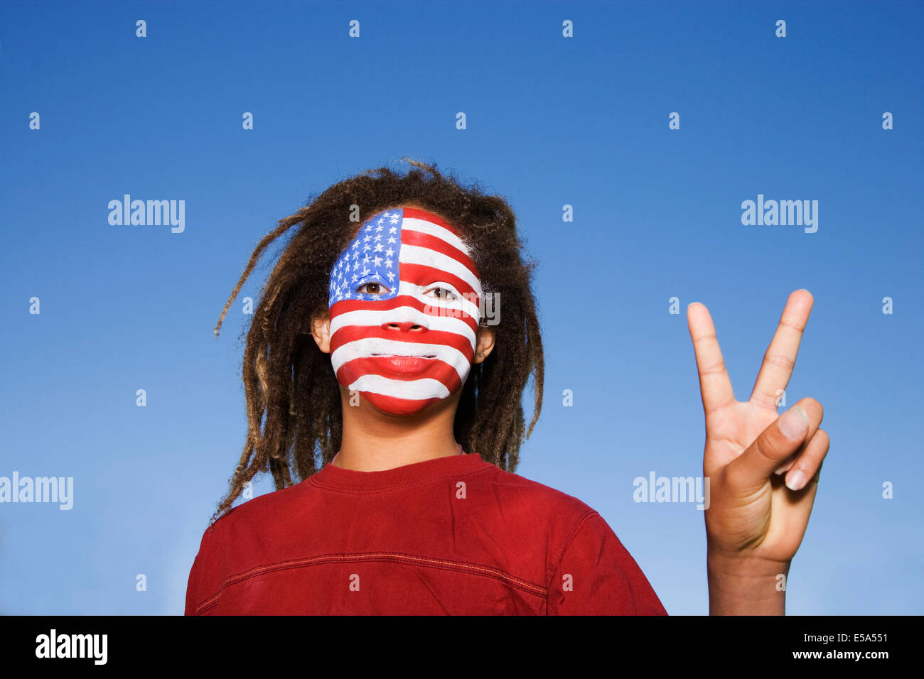 Mixed Race boy avec le drapeau américain peint sur le visage Banque D'Images