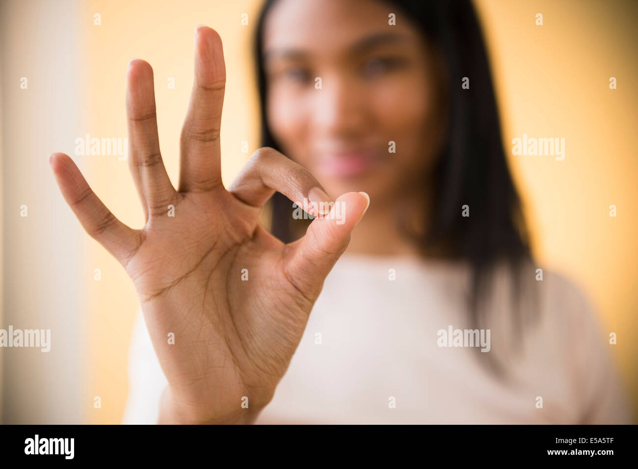 Mixed Race woman making symbole OK Banque D'Images