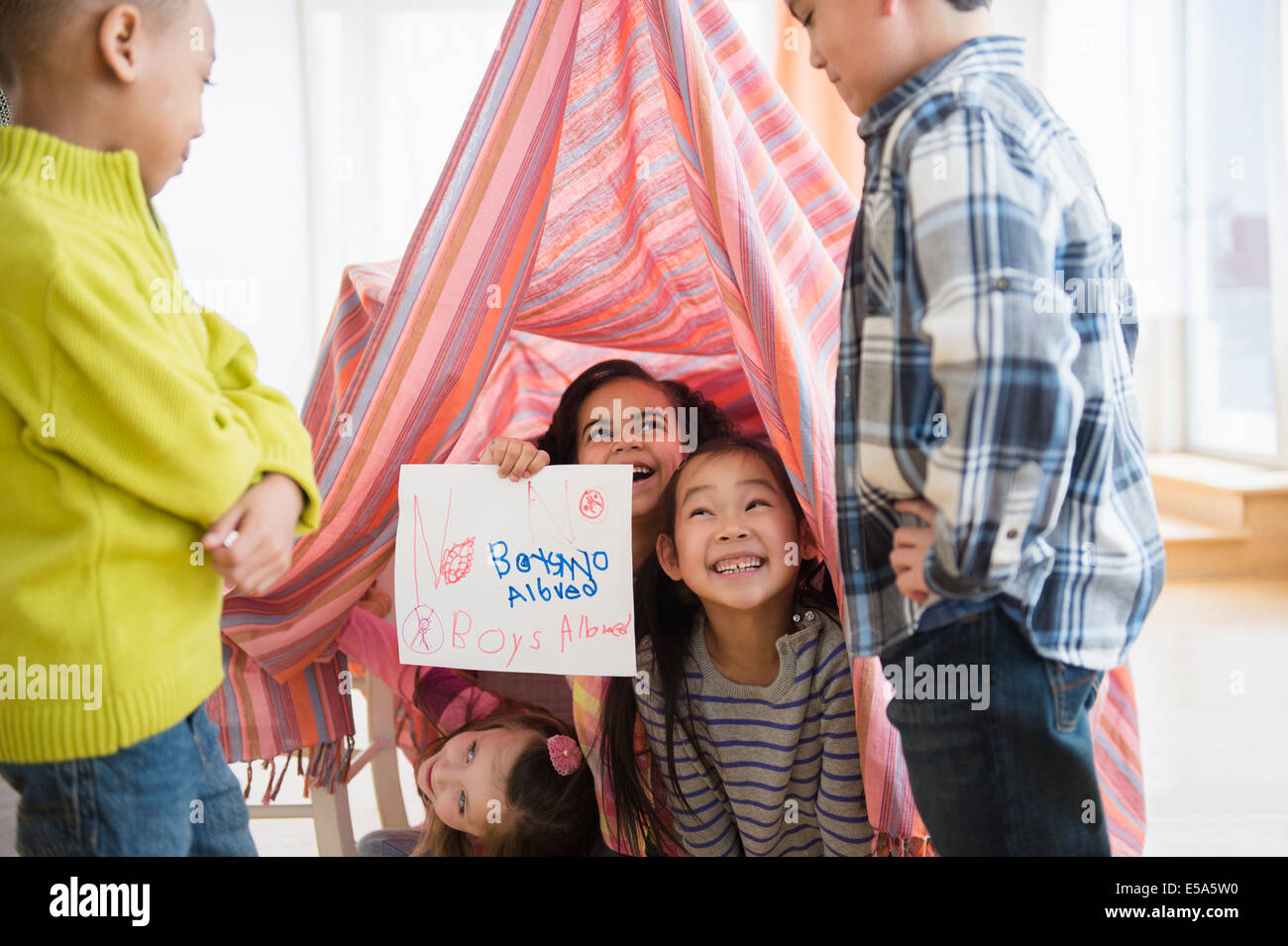 Filles Garçons admis aucune holding sign in living room Banque D'Images