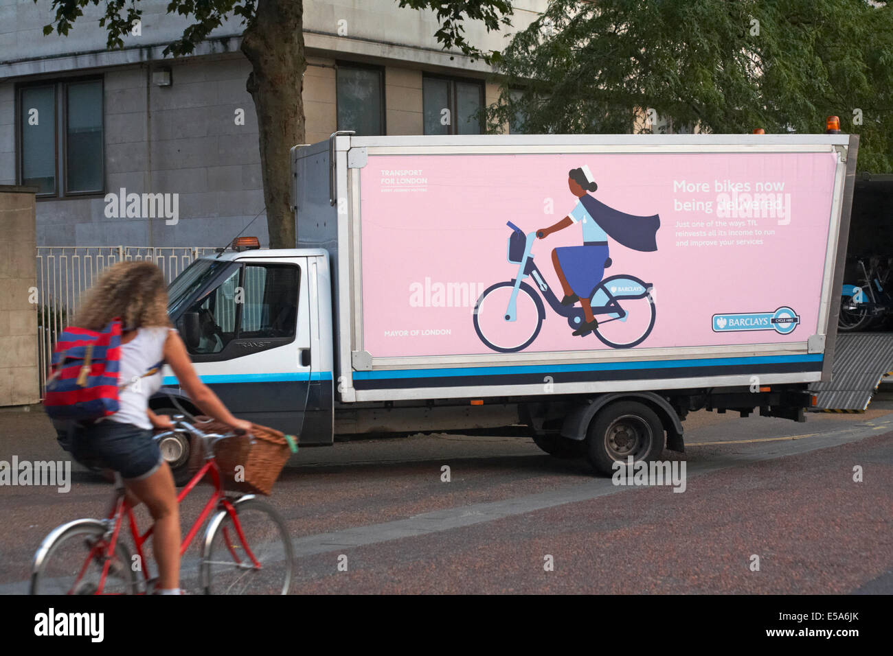 Woman riding bike passé plus de vélos en train d'être livré à Londres en Juillet Banque D'Images
