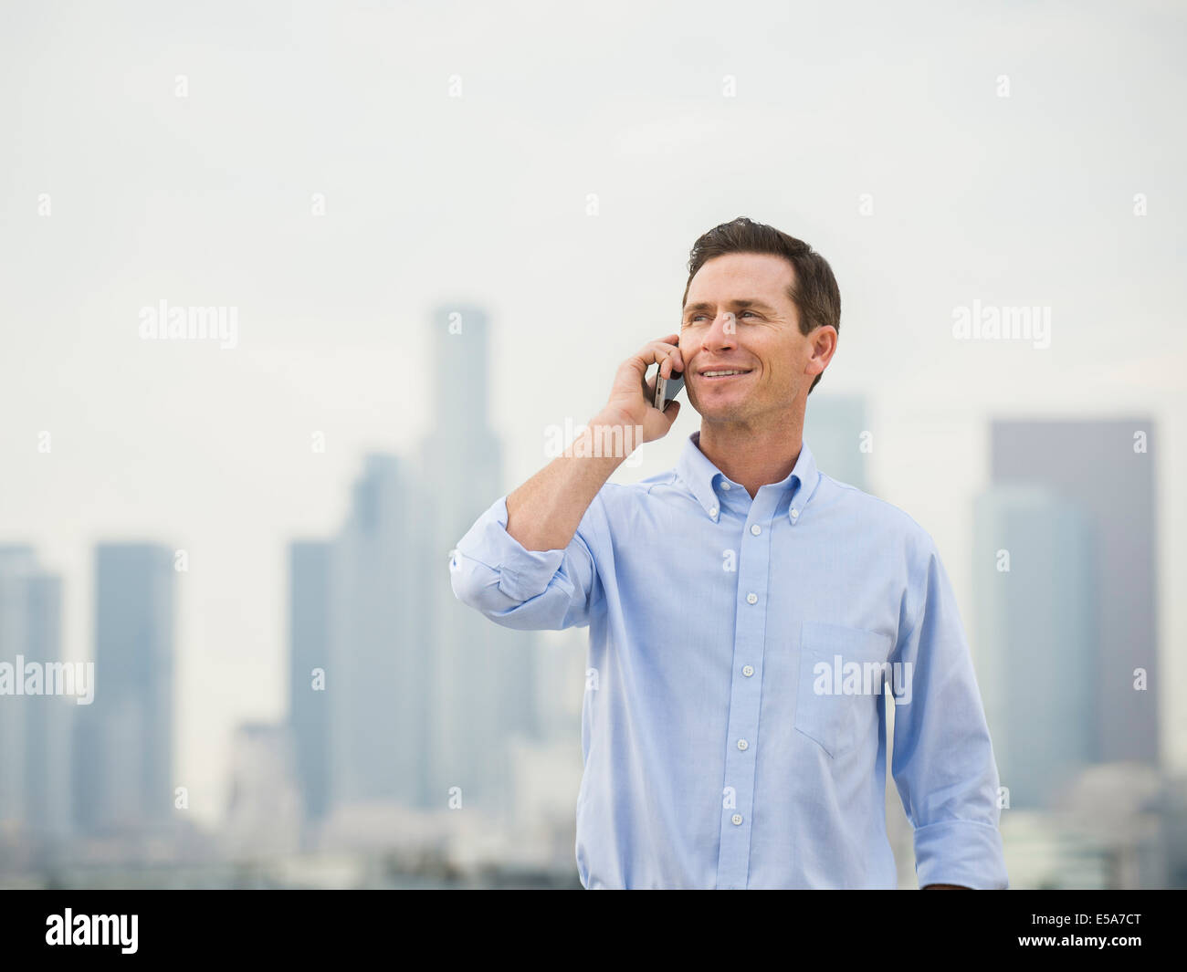 Caucasian businessman on cell phone on urban rooftop Banque D'Images