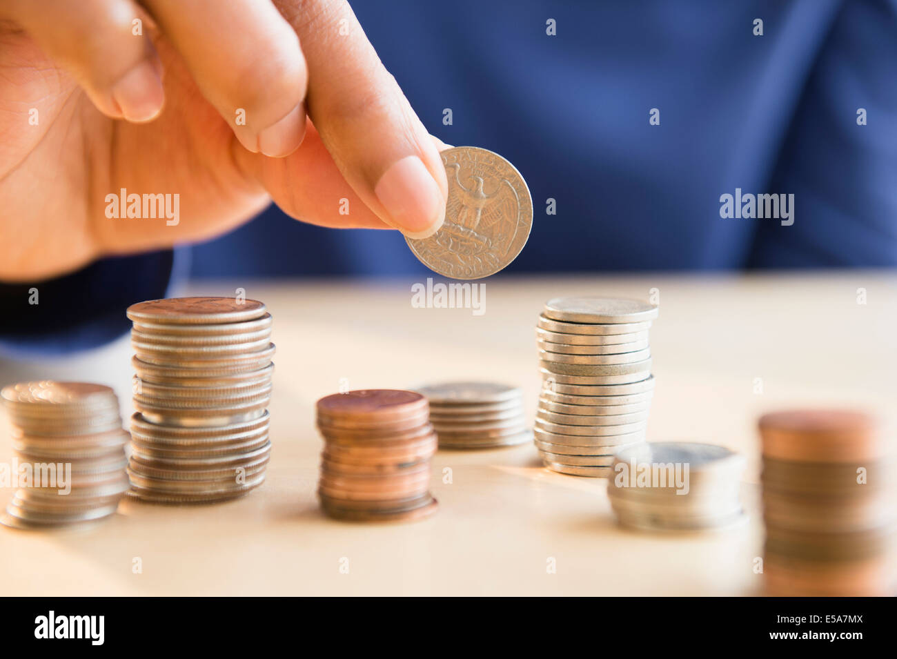 Mixed Race woman stacking coins Banque D'Images