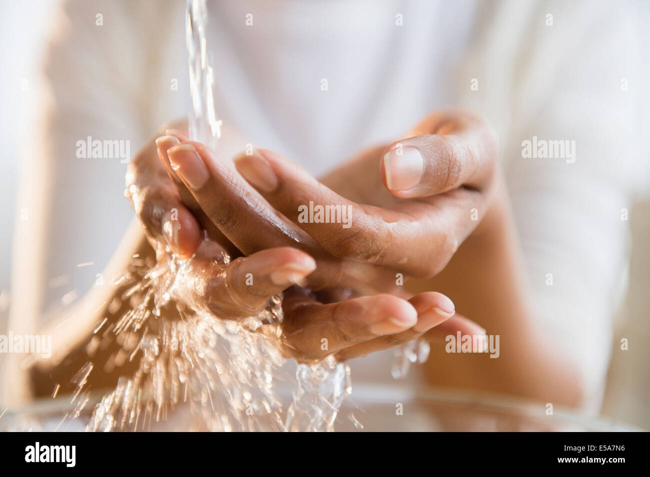 Mixed Race woman laver ses mains Banque D'Images