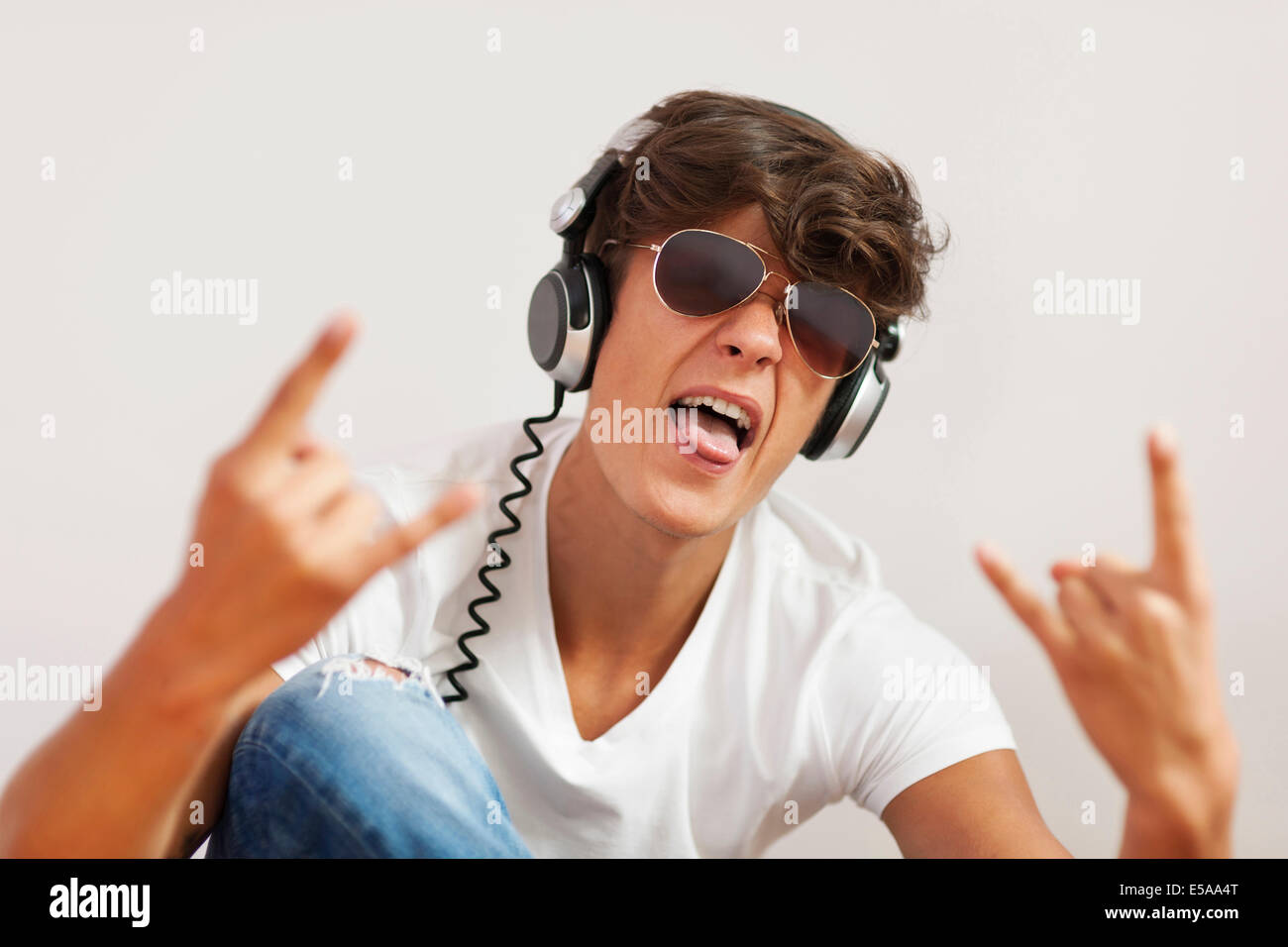 Jeune homme excité à l'écoute de la musique hard rock. Debica, Pologne Banque D'Images