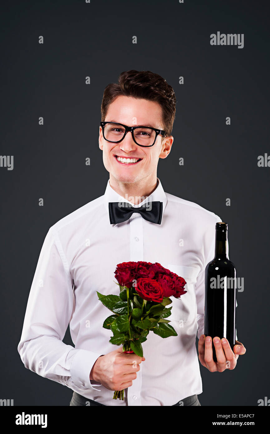 Bel homme avec le vin rouge et le bouquet de roses Debica, Pologne Banque D'Images