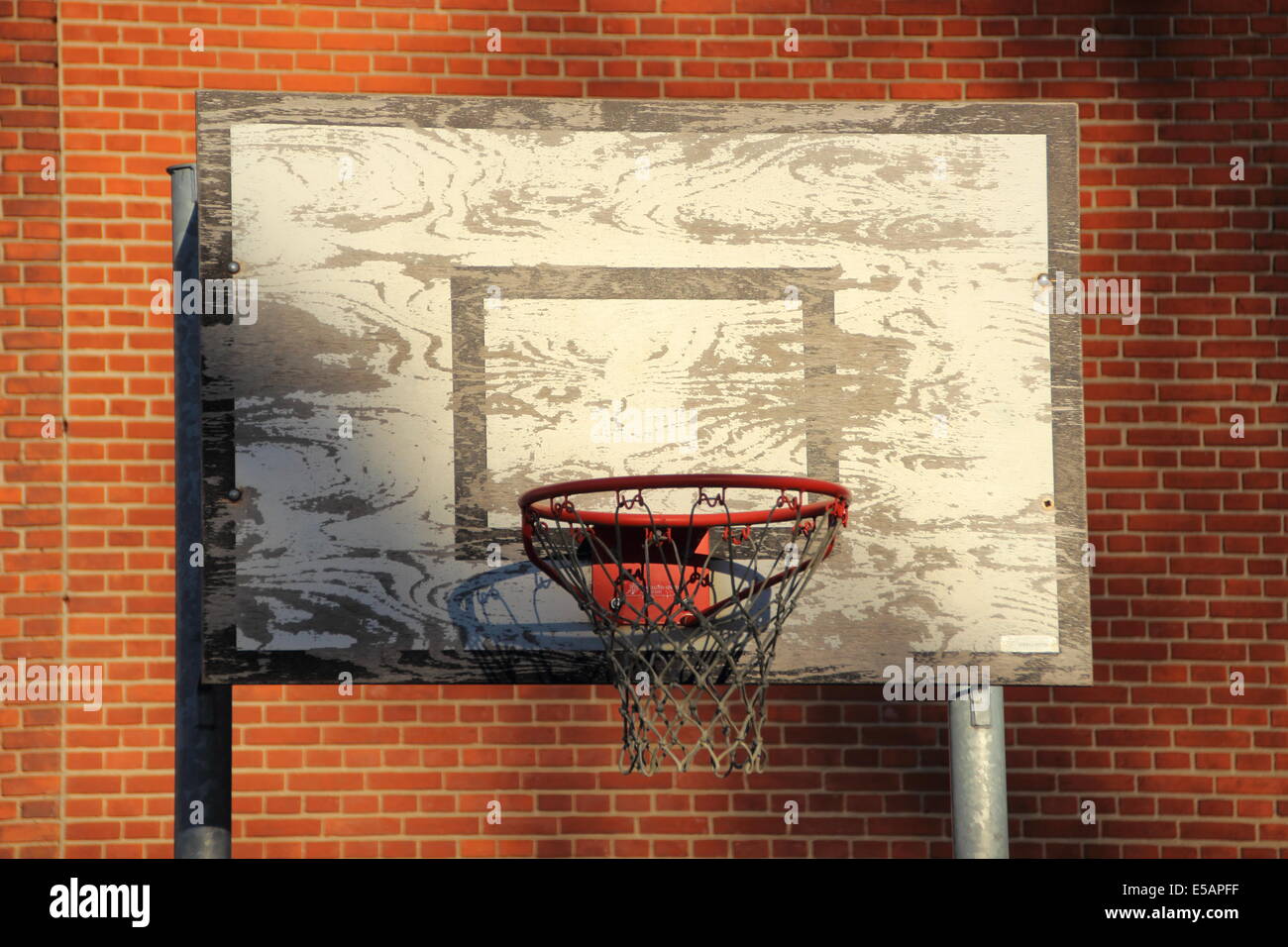 Vieux et usé de basket-ball extérieur net avec l'arrière-plan en brique rouge Banque D'Images