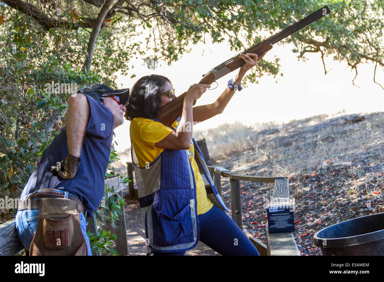 Femme indienne argiles tir avec un fusil de chasse avec moniteur lui enseignant comment filmer Banque D'Images