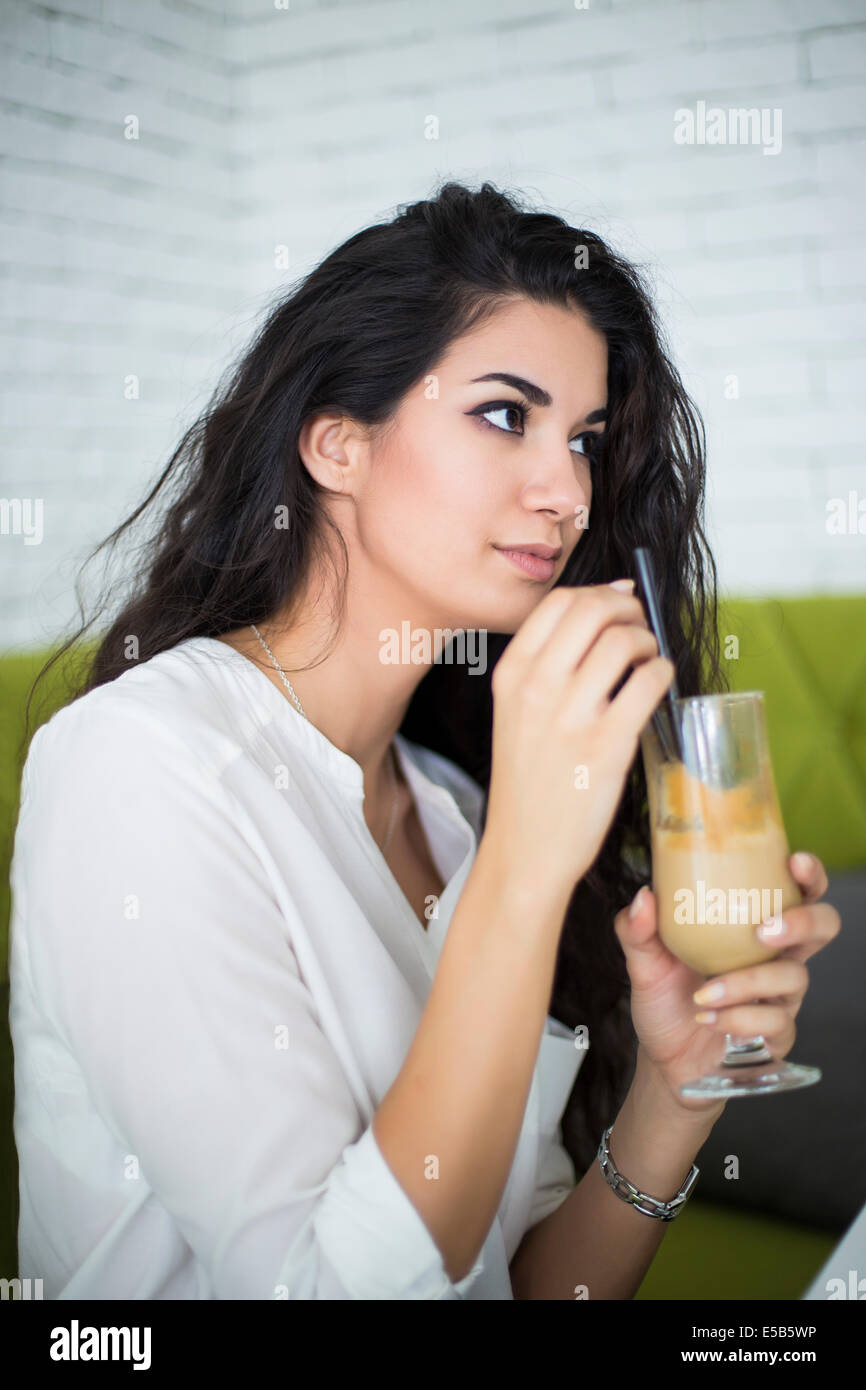 Young woman drinking coffee in cafe Banque D'Images