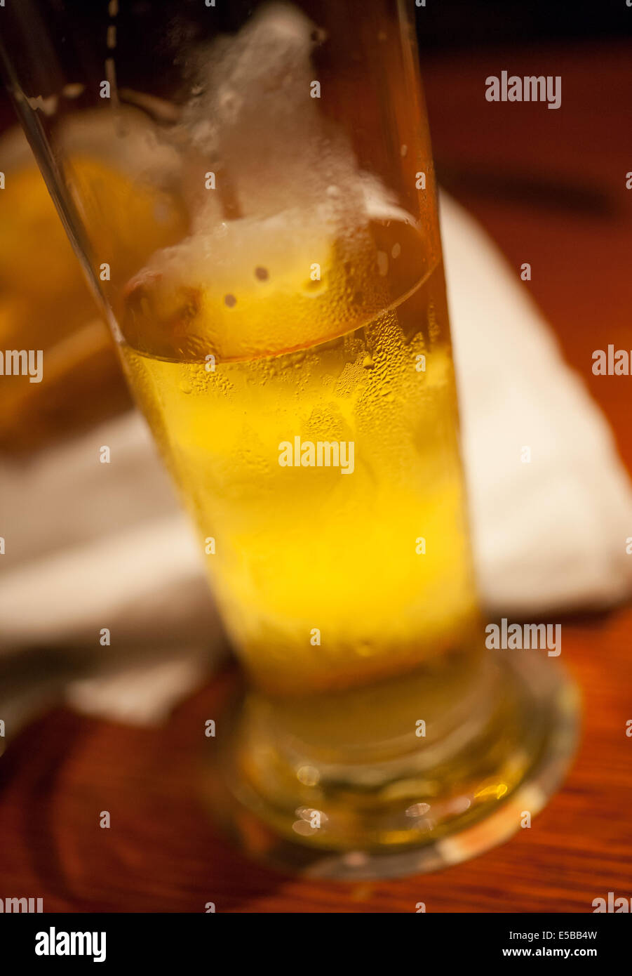Un verre de bière assis sur une table. Banque D'Images