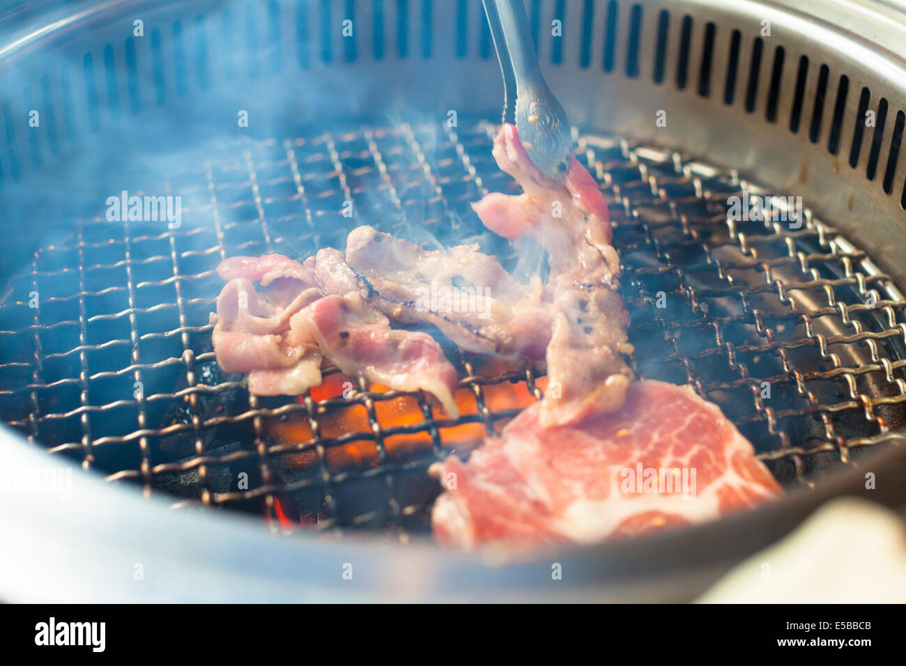 Libre de viande sur un grill ou un barbecue avec le smog Banque D'Images