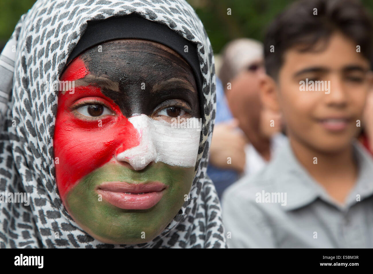 Dearborn, Michigan, USA. D'origine arabe rassemblement à Dearborn hôtel de ville pour protester contre l'action militaire d'Israël à Gaza. Plus de 1 000 Palestiniens ont été tués, pour la plupart des civils. Une jeune femme peint son visage, comme le drapeau de la Palestine. Crédit : Jim West/Alamy Live News Banque D'Images