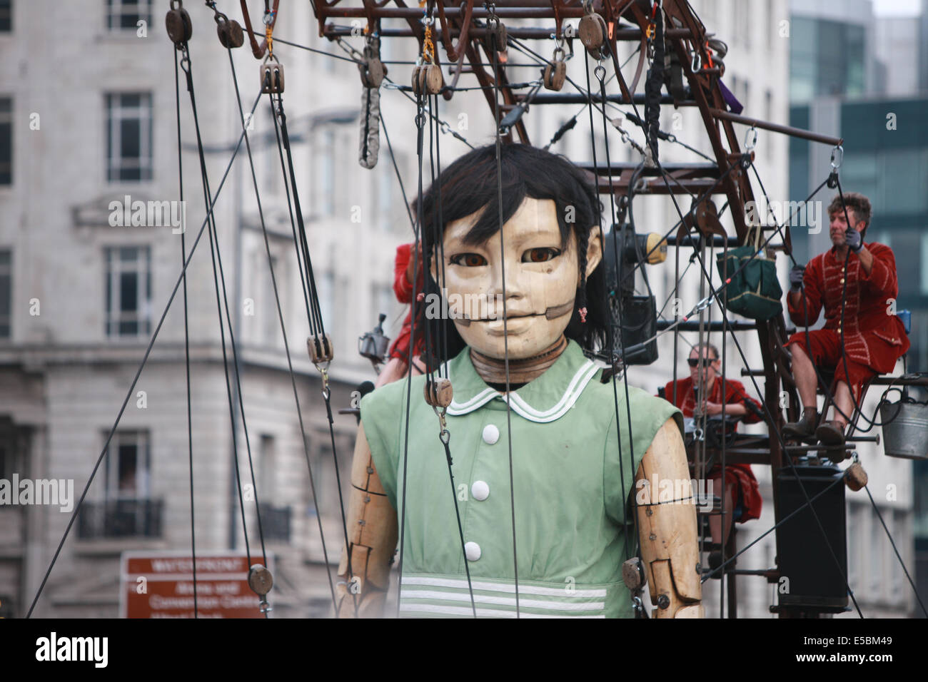 Liverpool, Royaume-Uni. 26 juillet, 2014. Petite fille près de Géant Pier Head, Liverpool sur son programme de marche autour du centre de Liverpool. Les géants retour à Liverpool, ayant été très populaire en 2012, et sont la création de la compagnie de théâtre de rue française "Royal de Luxe". Il est grand-mère, premier ministre britannique des géants. Les géants sont performants dans 'Mémoires d'août 1914" un conte de guerre storie liés à l'anniversaire 100 ans du début de la Première Guerre mondiale. crédit : Paul Quayle/Alamy Live News Banque D'Images