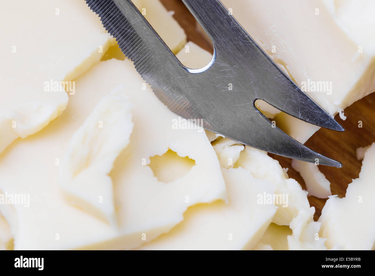 Tranches de fromage blanc maasdam avec couteau sur sol en bois Banque D'Images
