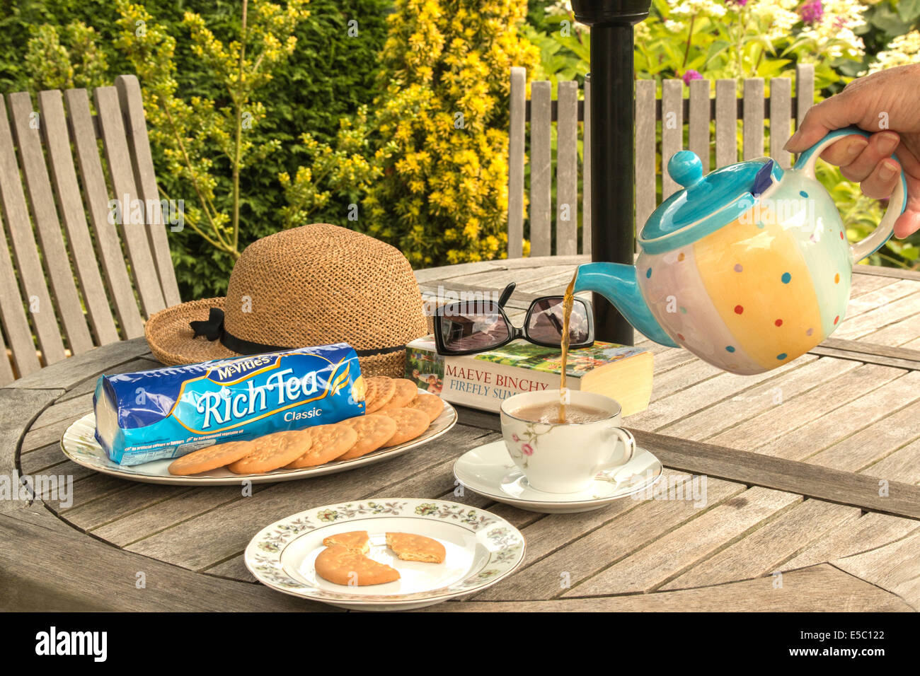 On verse le thé d'avoir avec des biscuits pour le thé dans le jardin (2 de 2) Banque D'Images