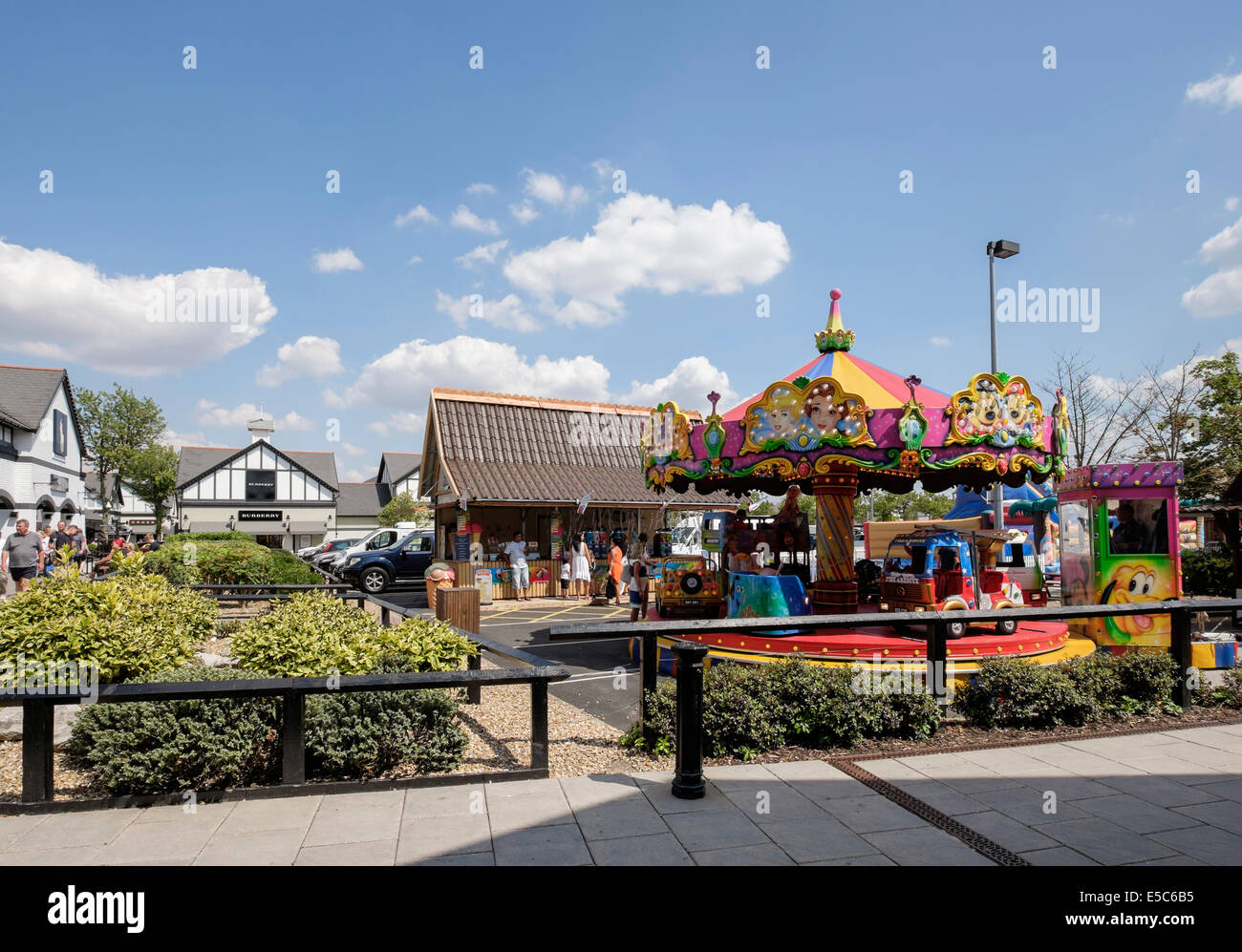 Les enfants merry-go-round carousel au Cheshire Oaks Designer shopping outlet. Ellesmere Port, Cheshire, Angleterre, Royaume-Uni, Angleterre Banque D'Images