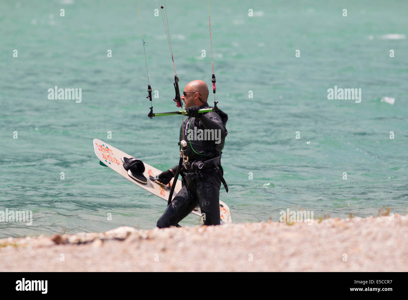 Lac DE SANTA CROCE, ITALIE - 13 juillet 2014 : Kitesurfer lance son cerf-volant dans le lac de Santa Croce Banque D'Images
