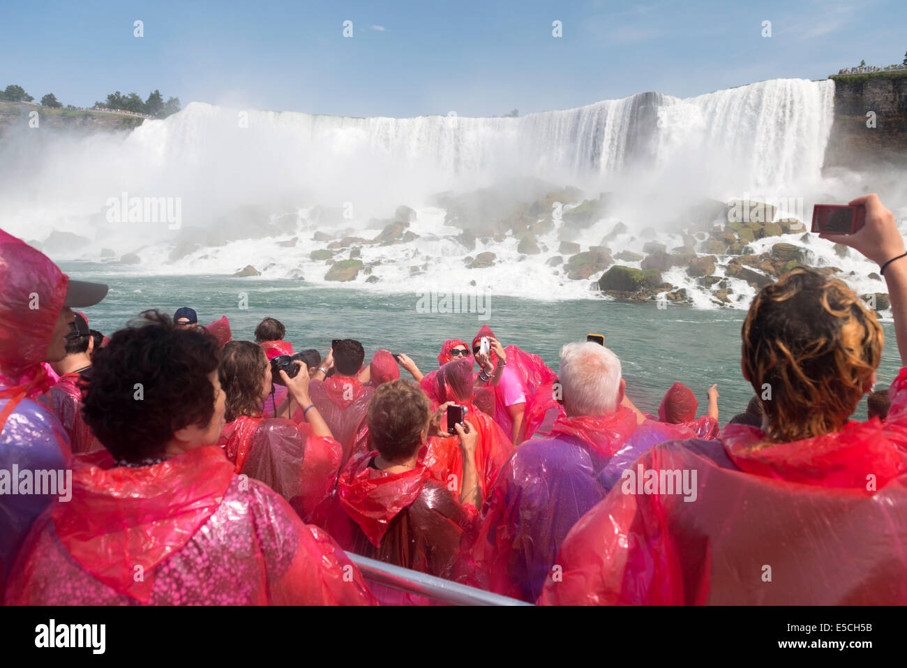 Les gens en rose d'imperméables sur un bateau aux chutes du Niagara. Hornblower Cruises Niagara, Ontario, Canada 2014. Banque D'Images
