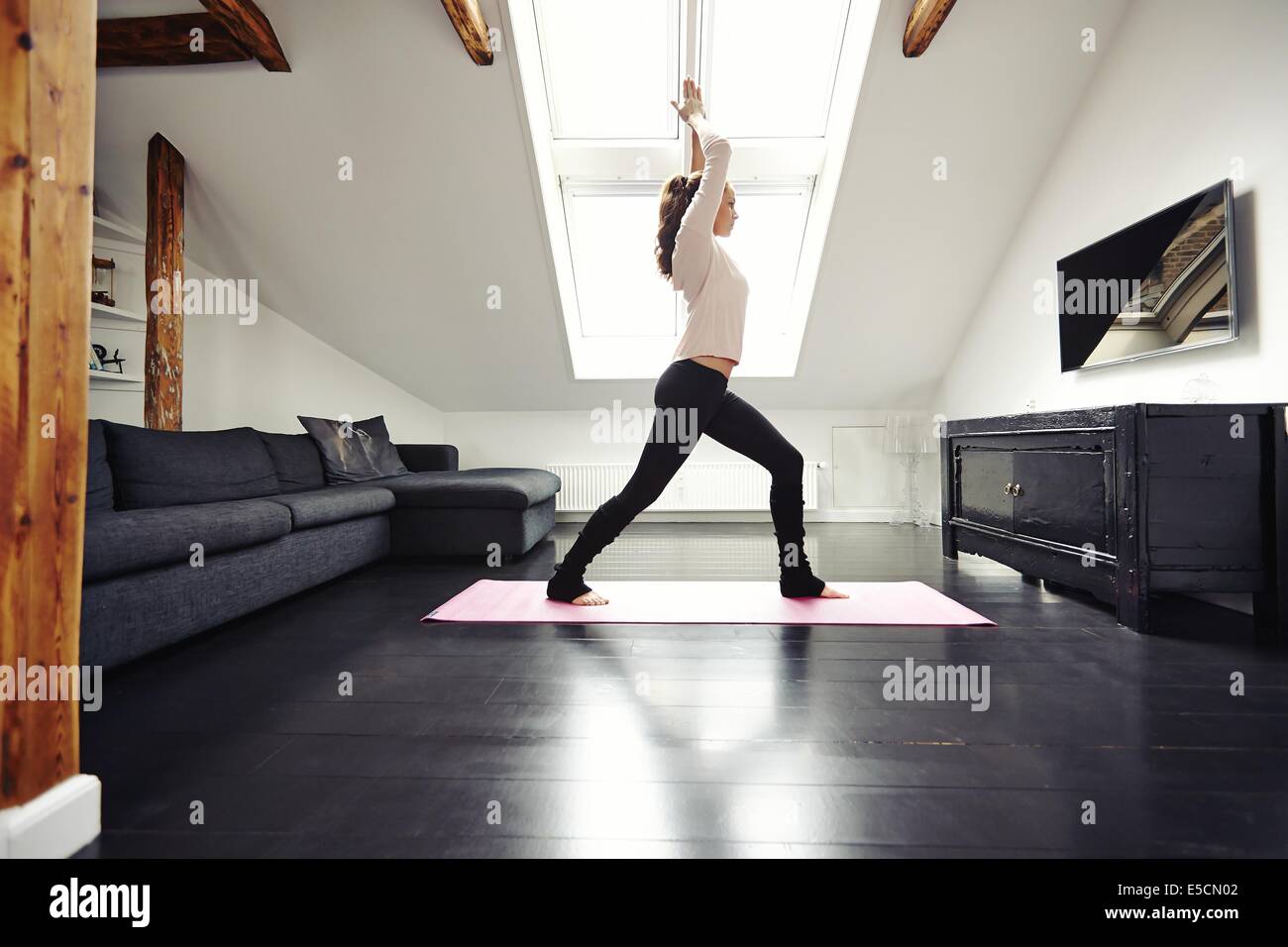 Fit young woman doing yoga à la maison. Modèle féminin en bonne santé vivant dans l'exercice de la maison. Banque D'Images
