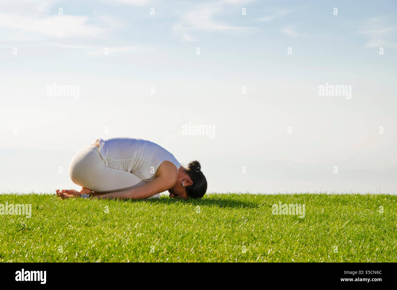 Jeune femme la pratique de l'hatha yoga, ici la posture garbhasana, posture de l'enfant Banque D'Images