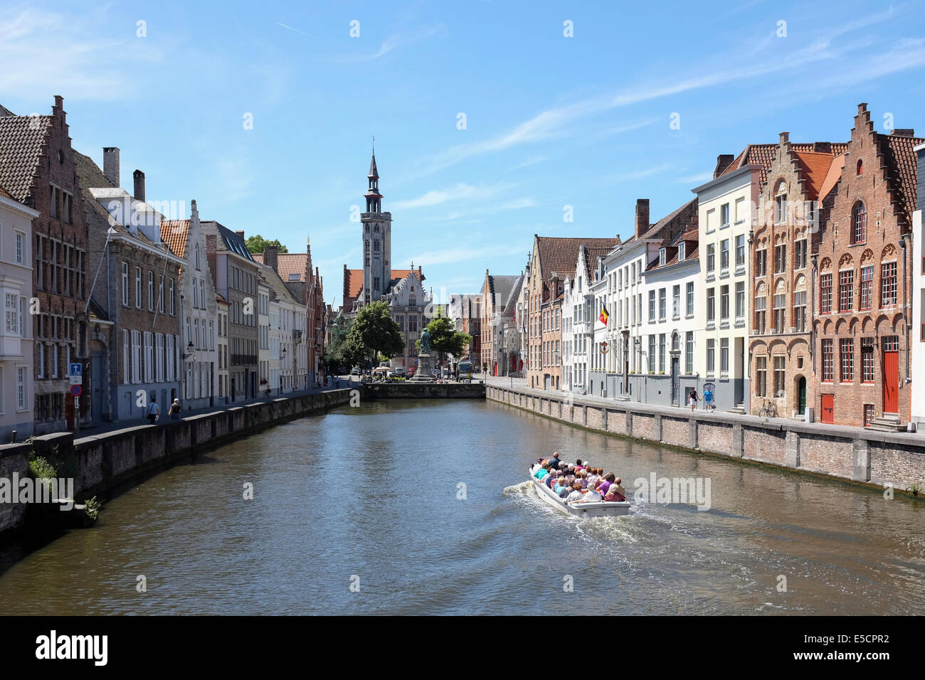 Les touristes sur un bateau sur le canal de Bruges, Belgique. La vieille maison sans frais à l'arrière-plan. Banque D'Images