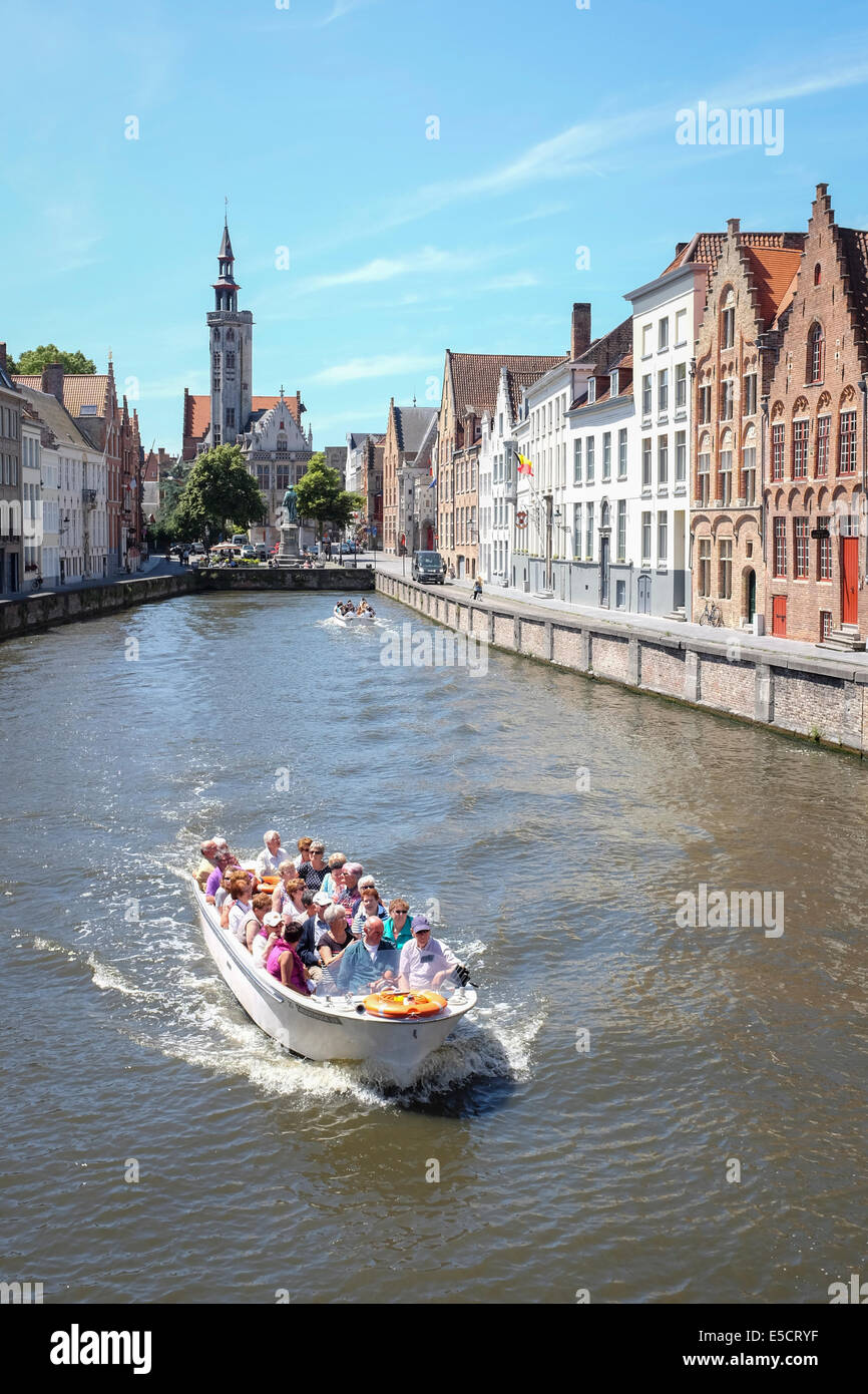 Les touristes sur un bateau sur le canal de Bruges, Belgique. La vieille maison sans frais à l'arrière-plan. Banque D'Images