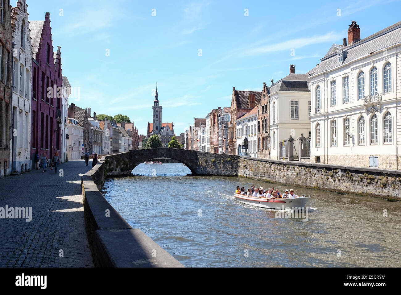 Les touristes sur un bateau sur le canal de Bruges, Belgique. La vieille maison sans frais à l'arrière-plan. Banque D'Images