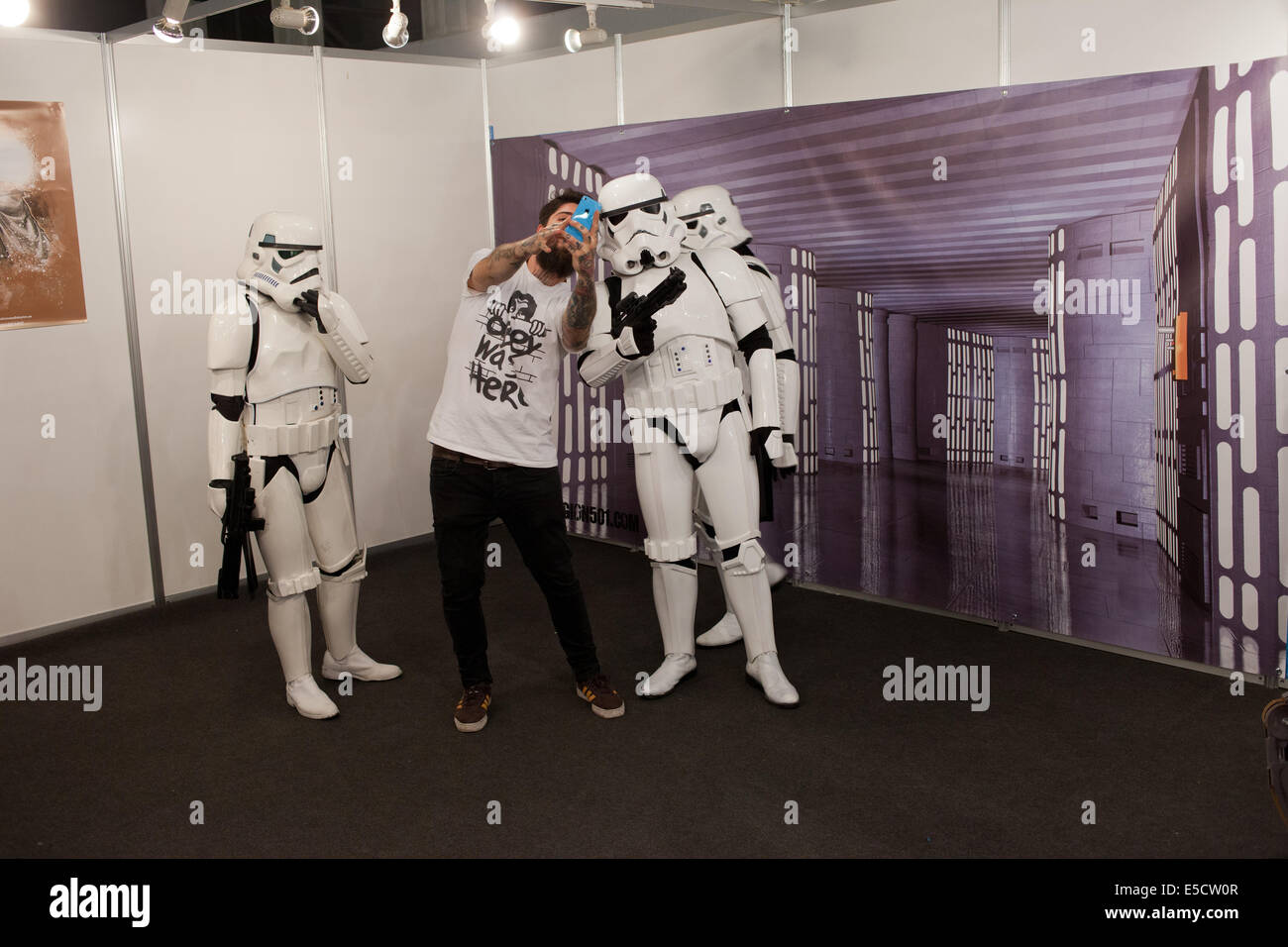 Homme prenant des photos avec Star Wars Stormtroopers à la Foire internationale de la Comique de Barcelone le 17 mai 2014 à Barcelone, Catalogne, Espagne. Banque D'Images