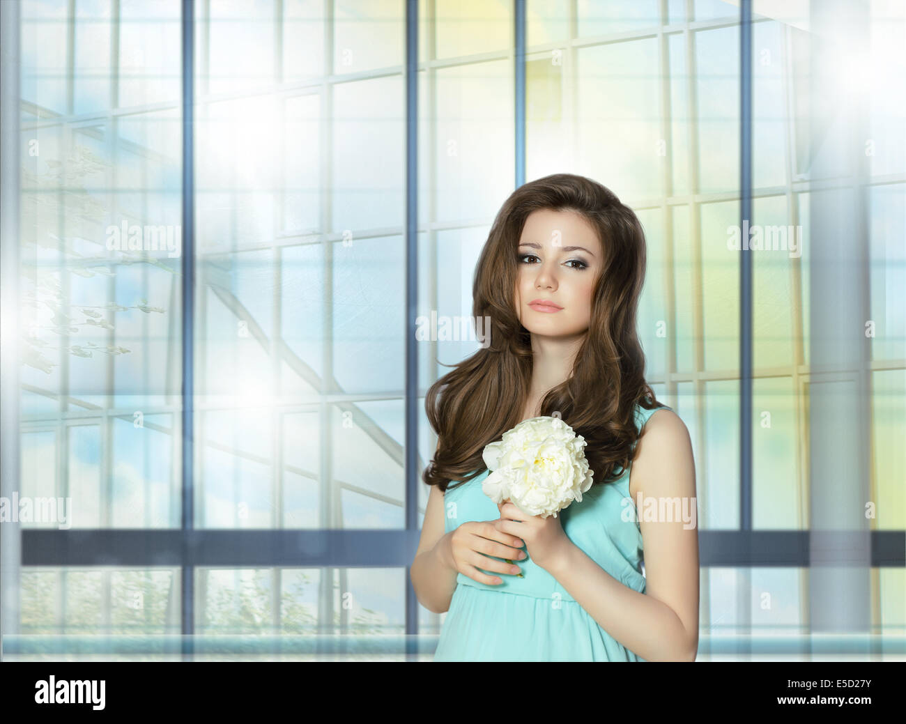 Jeune femme tenant des fleurs de pivoine sur la fenêtre Banque D'Images