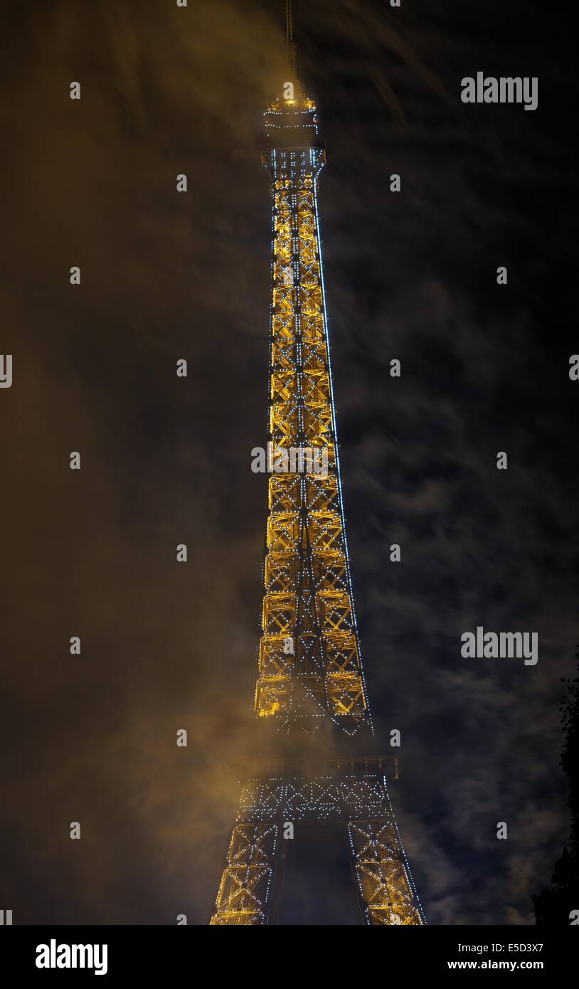 La fin de l'artifice de la fête de la Bastille, la Tour Eiffel en blanc et jaune dans la fumée des feux d'artifice Banque D'Images