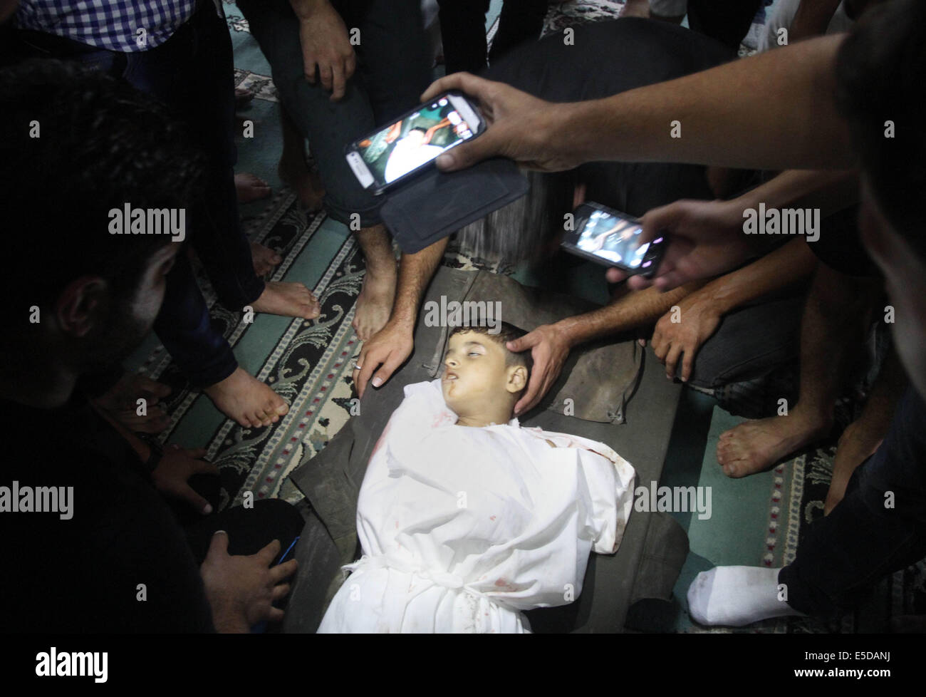 La ville de Gaza, bande de Gaza, territoire palestinien. 6 mai, 2010. Les Palestiniens se retrouvent autour d'enfant, Mohammad Abou Shaqfa 8, qui ont été tués dans une explosion dans un jeu public dans le camp de réfugiés de Shati en front de mer le 28 juillet 2014. Des sources médicales palestiniennes a blâmé les meurtres sur les frappes aériennes lancées par l'armée israélienne © Alaa Shamaly/APA/Images/fil ZUMA Alamy Live News Banque D'Images