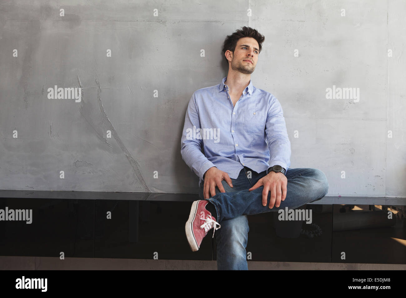 Portrait of smiling man leaning on wall Banque D'Images