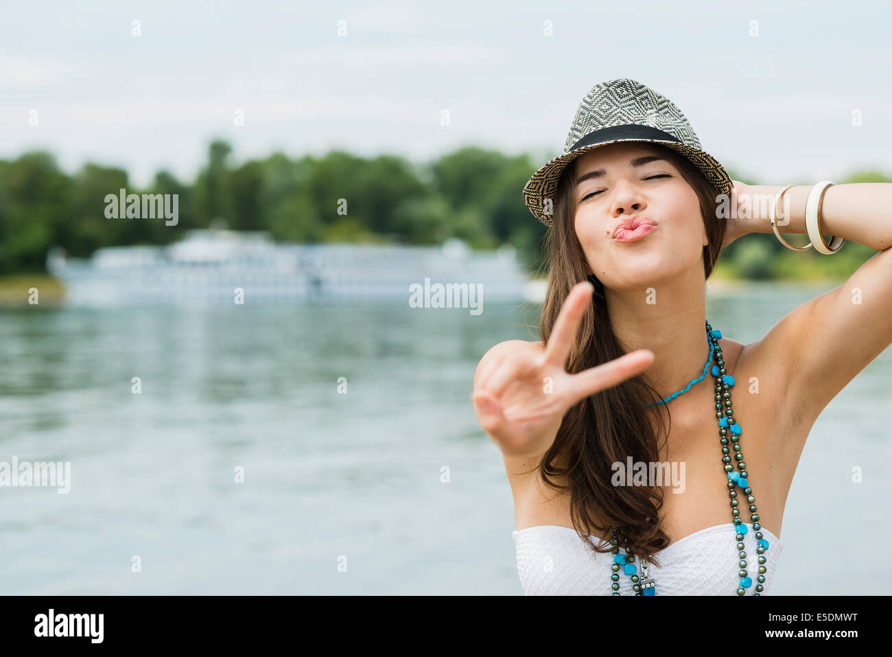 Portrait of smiling young woman showing victoire sur la plage Banque D'Images