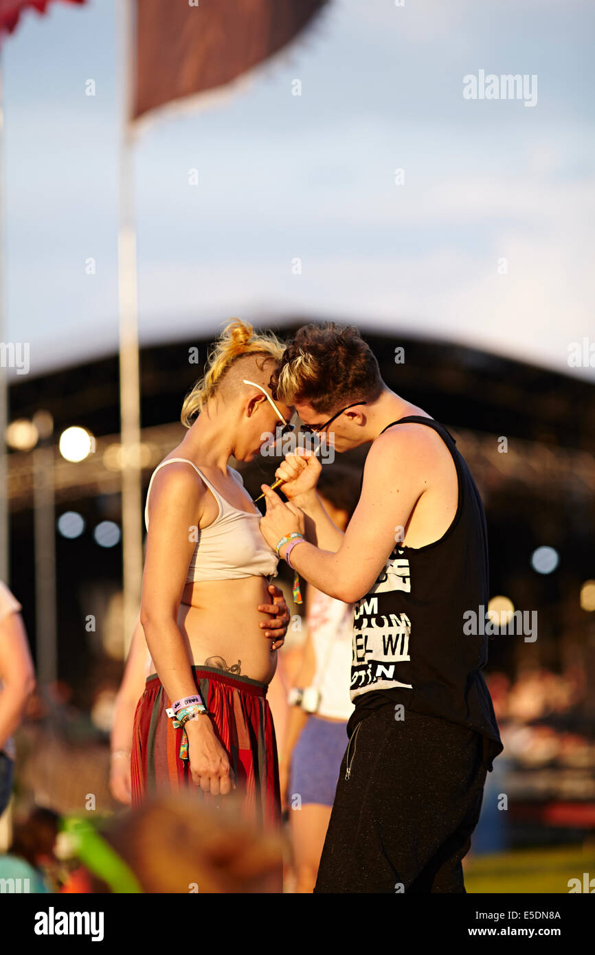 Festivaliers appliquer henné pour chaque autre music festival Womad à Charlton Park, Wiltshire, juillet 2014. Banque D'Images