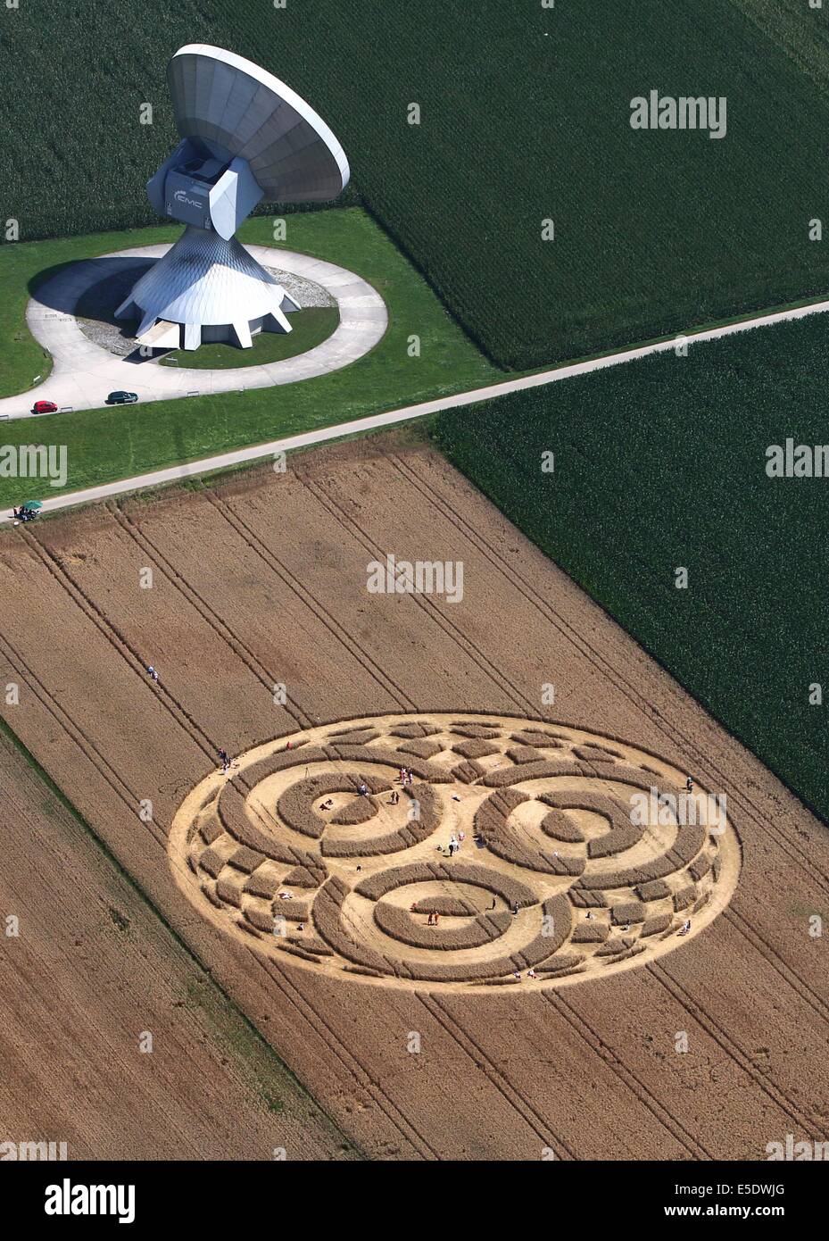Raisting, Allemagne. 28 juillet, 2014. Promenades visiteurs via un crop circle dans un champ de blé à côté d'une antenne de la station terrienne près de Raisting, Allemagne, 28 juillet 2014. Un aéronaute avait découvert l'agroglyphe il y a environ une semaine. Photo : Karl-Josef Opim/dpa/Alamy Live News Banque D'Images