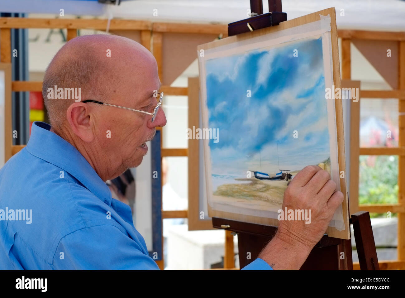 Artiste qui travaille sur une peinture à son échoppe de marché à palmerston road uk angleterre southsea Banque D'Images